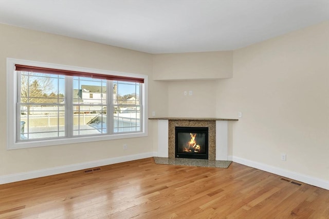 unfurnished living room with a premium fireplace and hardwood / wood-style floors