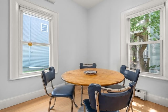 14 Grand View Ave, Somerville, MA 02143 - dining area featuring baseboards, light wood-style floors, and a baseboard heating unit