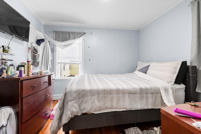 bedroom with crown molding and hardwood / wood-style floors