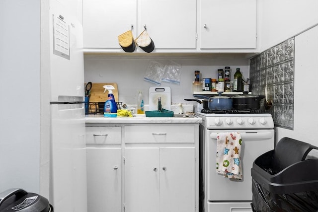 kitchen featuring white cabinetry and white range with gas cooktop