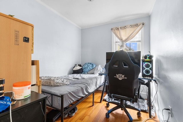 bedroom with crown molding and hardwood / wood-style flooring