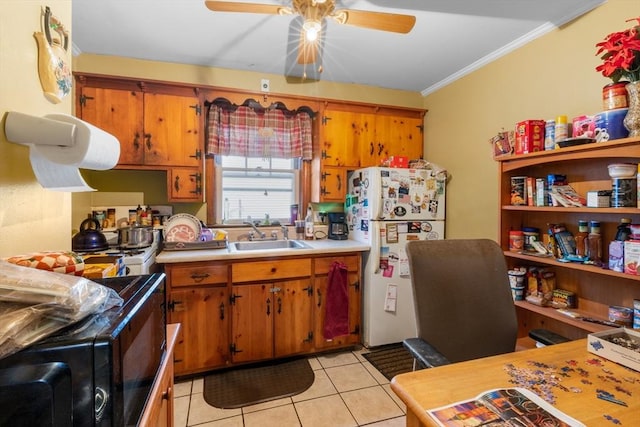 kitchen with white fridge, sink, ceiling fan, light tile patterned floors, and crown molding