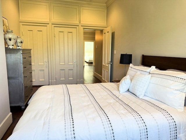 bedroom with dark wood finished floors and baseboards