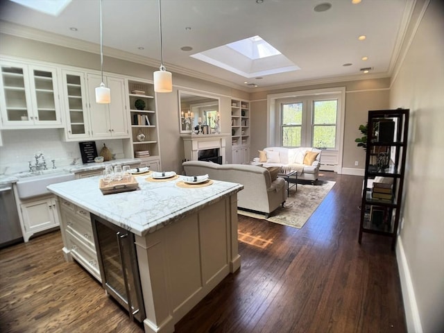 kitchen with a skylight, white cabinets, dark wood-style floors, a sink, and wine cooler