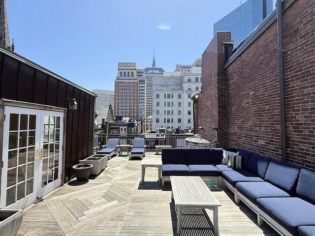 view of patio featuring an outdoor living space, french doors, a deck, and a view of city