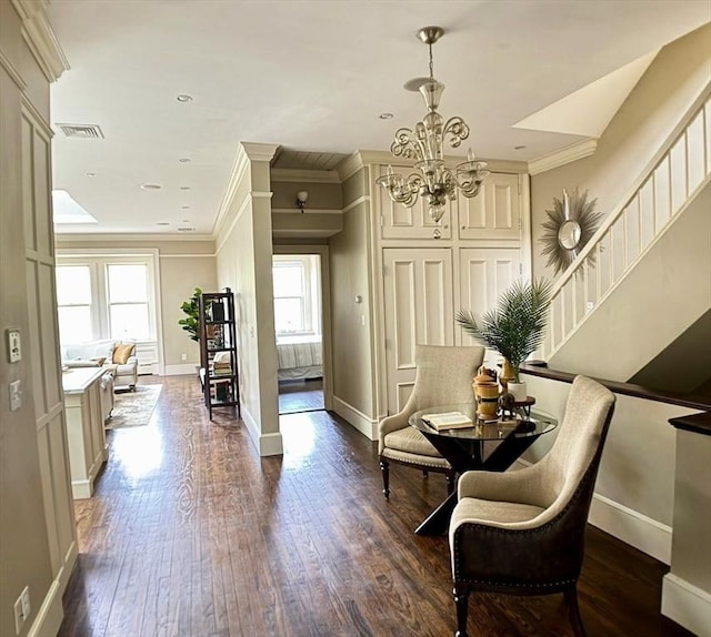 living area featuring crown molding, plenty of natural light, a chandelier, dark wood-style floors, and baseboards