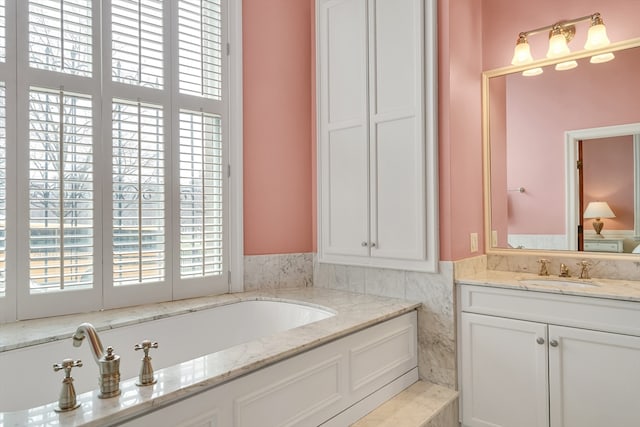 bathroom with vanity and tiled tub