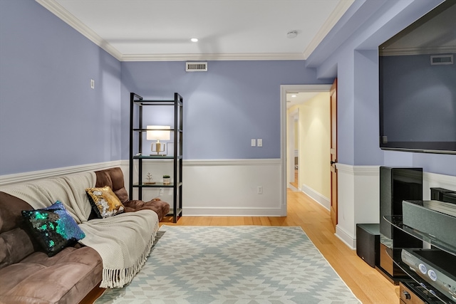 living room with ornamental molding and light hardwood / wood-style flooring