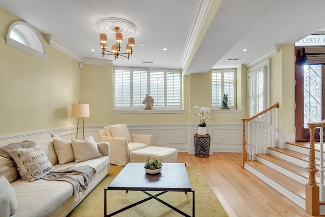 living room with a notable chandelier, light hardwood / wood-style flooring, and plenty of natural light