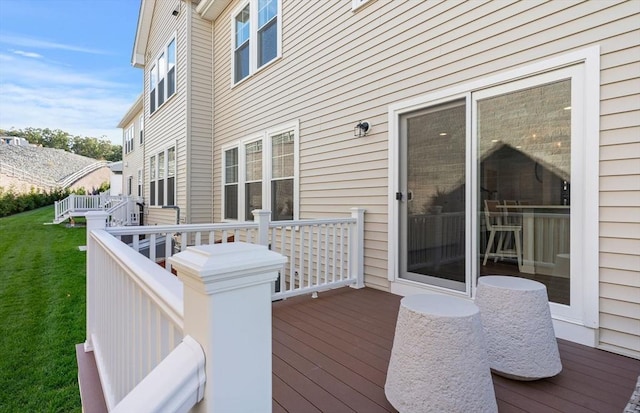 wooden deck featuring a lawn