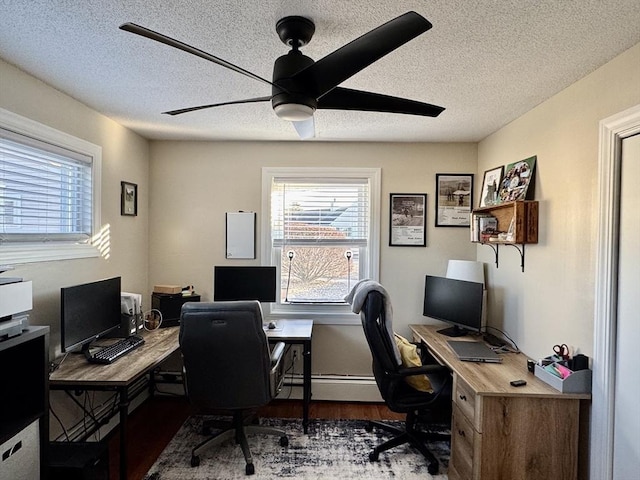 office area featuring ceiling fan, baseboard heating, a textured ceiling, and dark hardwood / wood-style floors