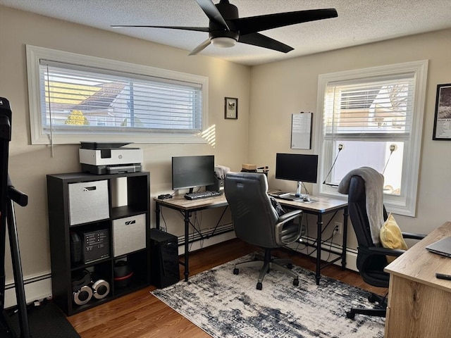 office space with ceiling fan, hardwood / wood-style floors, a textured ceiling, and a baseboard radiator