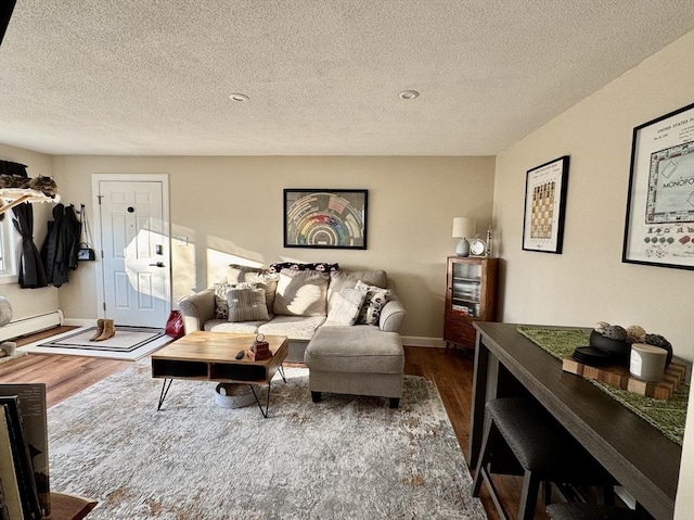 living room with a textured ceiling, baseboard heating, and dark hardwood / wood-style floors