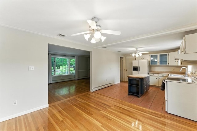 205 Mosier St, South Hadley, MA 01075 - kitchen with white appliances, a baseboard heating unit, under cabinet range hood, a ceiling fan, and white cabinetry