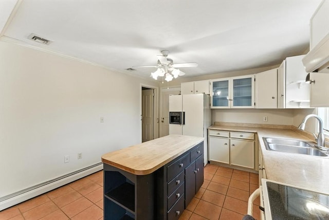 205 Mosier St, South Hadley, MA 01075 - kitchen with open shelves, a baseboard radiator, light tile patterned floors, white fridge with ice dispenser, and crown molding