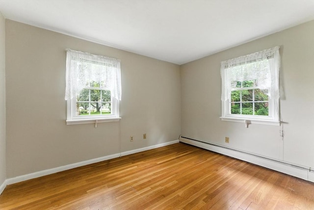 205 Mosier St, South Hadley, MA 01075 - empty room with a baseboard heating unit and light wood-style flooring
