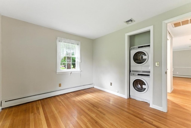 205 Mosier St, South Hadley, MA 01075 - laundry area with stacked washing machine and dryer, a baseboard radiator, and wood finished floors