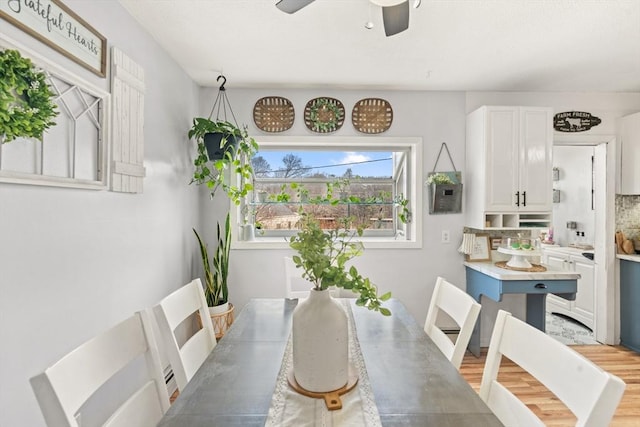 dining area featuring a ceiling fan and light wood-style floors