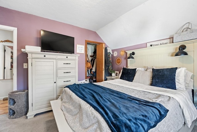 bedroom with lofted ceiling, carpet flooring, a closet, and a textured ceiling