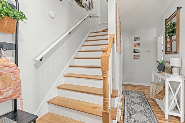 stairs with baseboards and wood finished floors