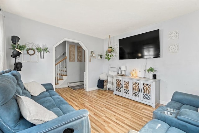 living room with baseboards, stairway, wood finished floors, arched walkways, and a baseboard radiator