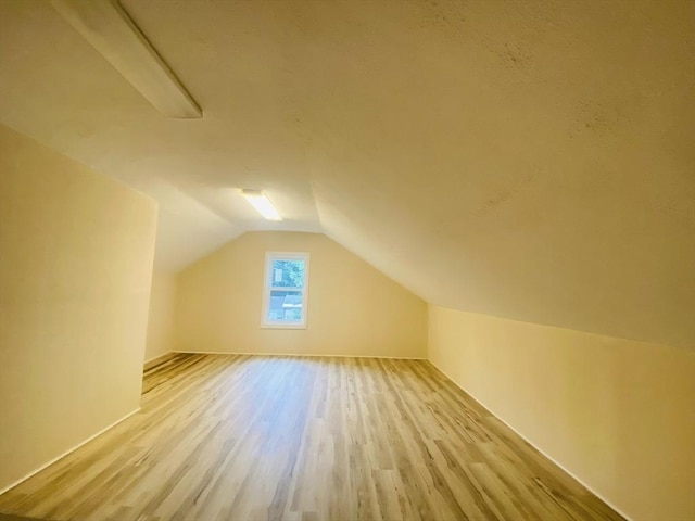 bonus room featuring light hardwood / wood-style flooring and vaulted ceiling