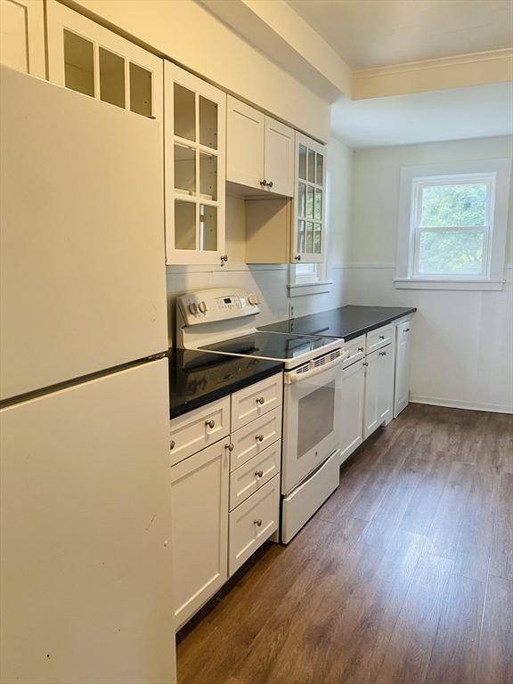kitchen featuring white cabinetry, white appliances, and dark wood-type flooring