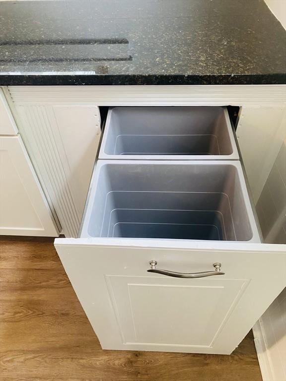 details with white cabinetry and dark wood-type flooring