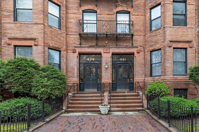 doorway to property featuring fence and a balcony
