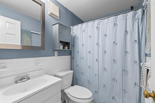 full bathroom featuring toilet, vanity, a shower with shower curtain, and tile walls