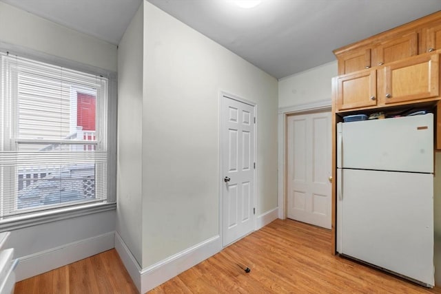 kitchen featuring light wood-style floors, baseboards, and freestanding refrigerator