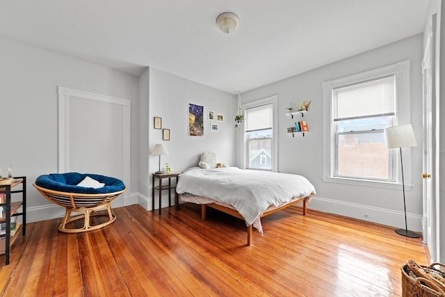 bedroom featuring hardwood / wood-style flooring and baseboards