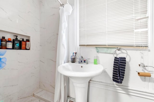 bathroom with a shower stall and a sink