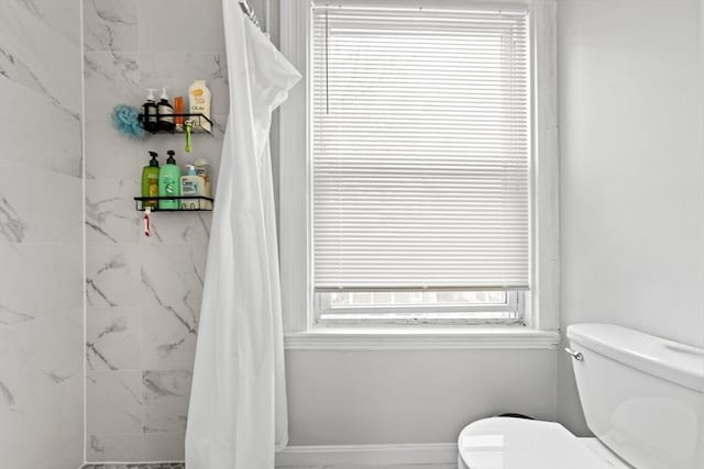 full bathroom featuring toilet and a shower with shower curtain