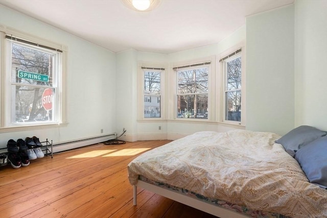 bedroom featuring hardwood / wood-style floors and baseboard heating