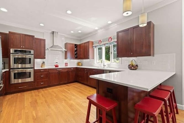 51 Fox Run Rd, Sudbury, MA 01776 - kitchen featuring wall chimney exhaust hood, stainless steel double oven, crown molding, a peninsula, and light countertops