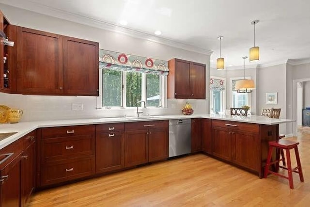 51 Fox Run Rd, Sudbury, MA 01776 - kitchen featuring stainless steel dishwasher, crown molding, a peninsula, a kitchen breakfast bar, and light countertops