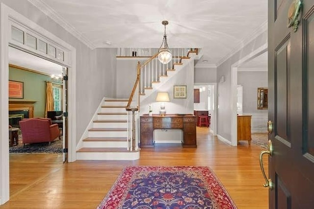 51 Fox Run Rd, Sudbury, MA 01776 - foyer entrance with stairs, wood finished floors, a chandelier, a fireplace, and ornamental molding