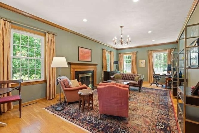 51 Fox Run Rd, Sudbury, MA 01776 - living area with ornamental molding, wood finished floors, a chandelier, a glass covered fireplace, and recessed lighting