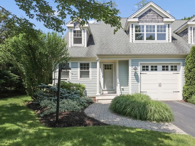 21 Pine St Unit 1A, Falmouth, MA 02556 - view of front of house with a shingled roof, a garage, asphalt driveway, and a front lawn