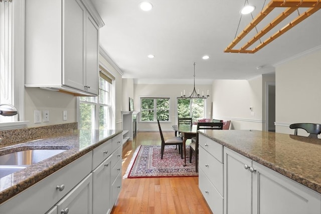 21 Pine St Unit 1A, Falmouth, MA 02556 - kitchen featuring light wood finished floors, recessed lighting, dark stone counters, a chandelier, and hanging light fixtures