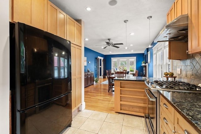 338 Forest St, Arlington, MA 02474 - kitchen featuring black fridge, stainless steel range with gas stovetop, wall chimney exhaust hood, a ceiling fan, and light tile patterned floors