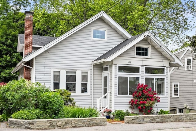 338 Forest St, Arlington, MA 02474 - view of front of house featuring a chimney, entry steps, and roof with shingles