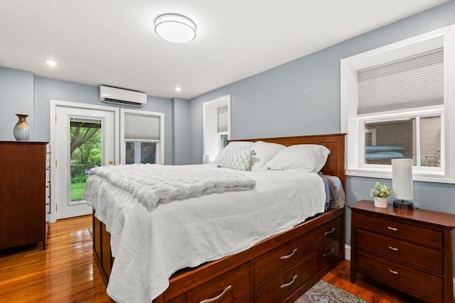 338 Forest St, Arlington, MA 02474 - bedroom featuring a wall unit AC, access to outside, wood finished floors, and recessed lighting