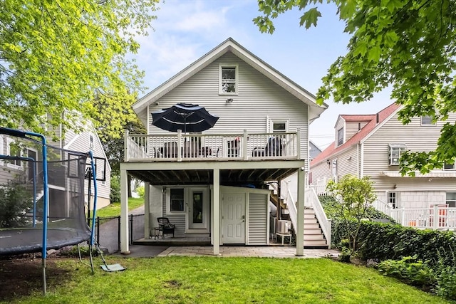 338 Forest St, Arlington, MA 02474 - rear view of property featuring a trampoline, a wooden deck, a yard, stairway, and a patio