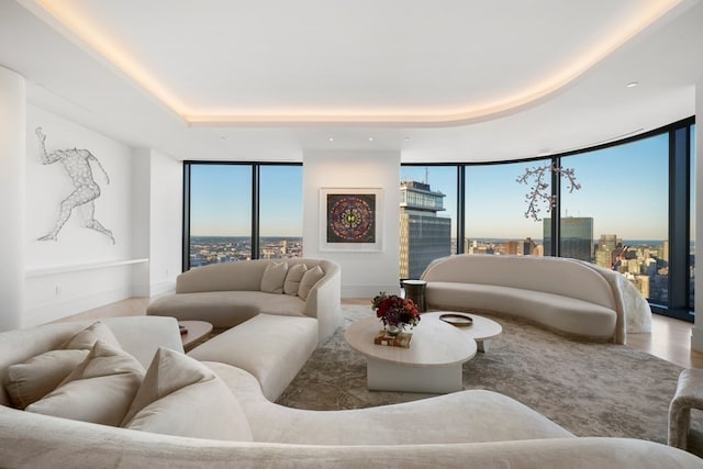 living room with a tray ceiling, plenty of natural light, and floor to ceiling windows