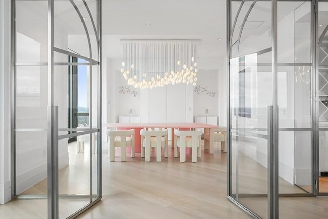 bathroom featuring expansive windows, wood finished floors, and an inviting chandelier