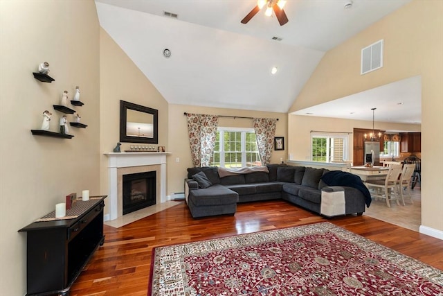 55 Arbor Rd, Uxbridge, MA 01569 - living room featuring wood finished floors, a fireplace with flush hearth, ceiling fan, baseboard heating, and high vaulted ceiling