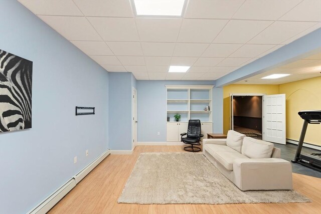 55 Arbor Rd, Uxbridge, MA 01569 - living area featuring a baseboard radiator, wood finished floors, baseboards, a drop ceiling, and baseboard heating