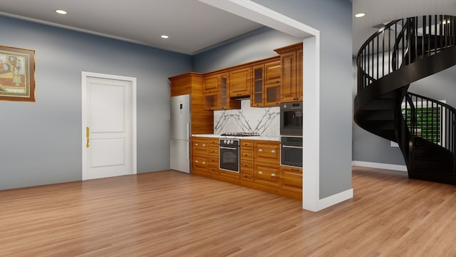 kitchen with tasteful backsplash, light hardwood / wood-style flooring, stainless steel gas cooktop, and white refrigerator